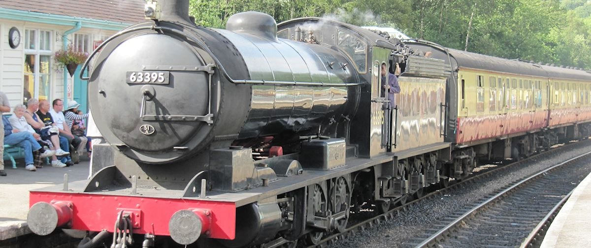 A large black steam train sitting at the station